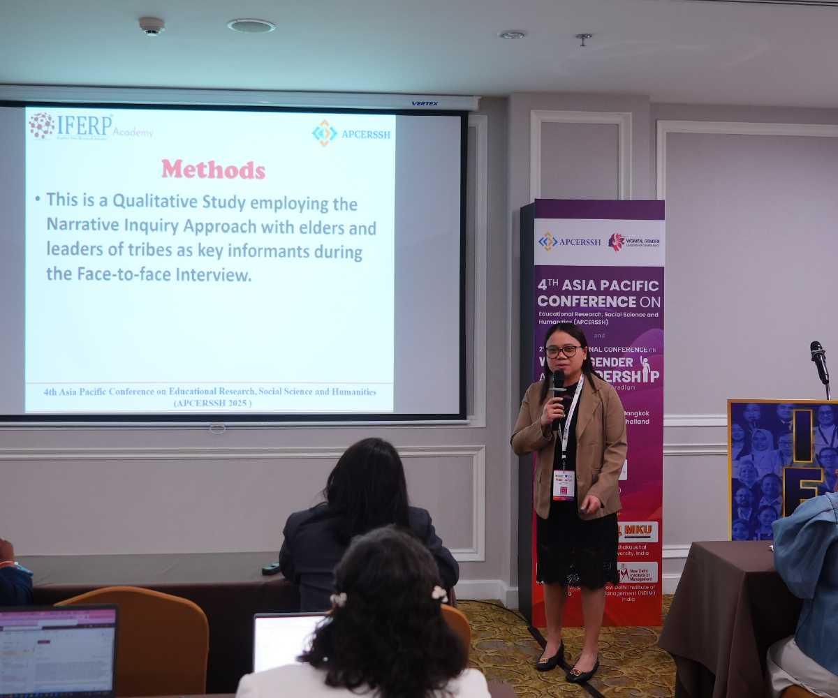 A presenter speaking beside a projected slide deck