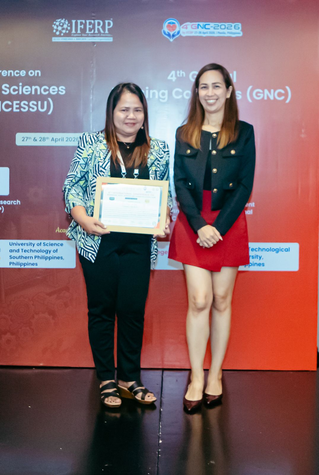 A presenter receiving a framed certificate of participation on stage