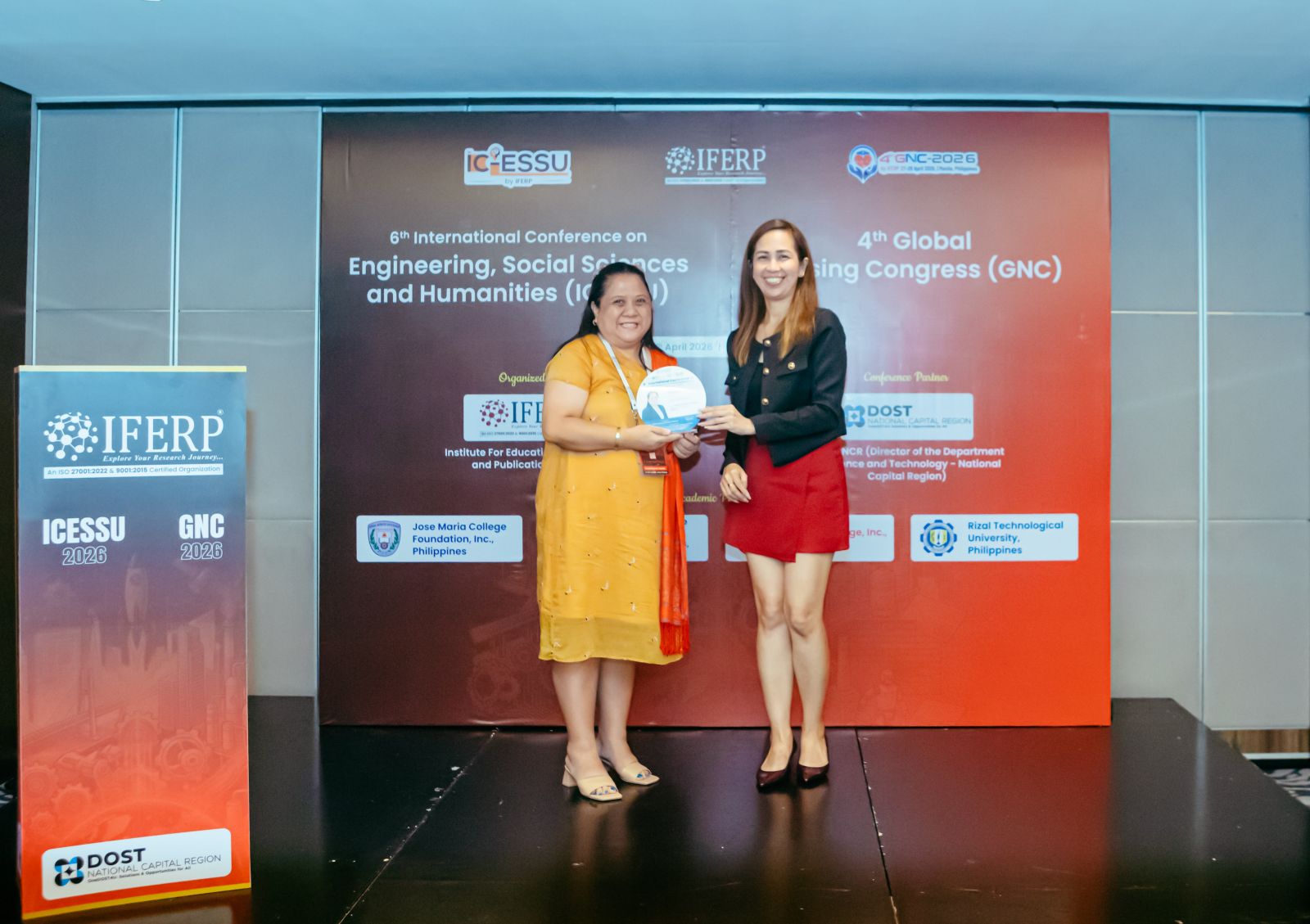 A delegate receiving a commemorative plaque on stage