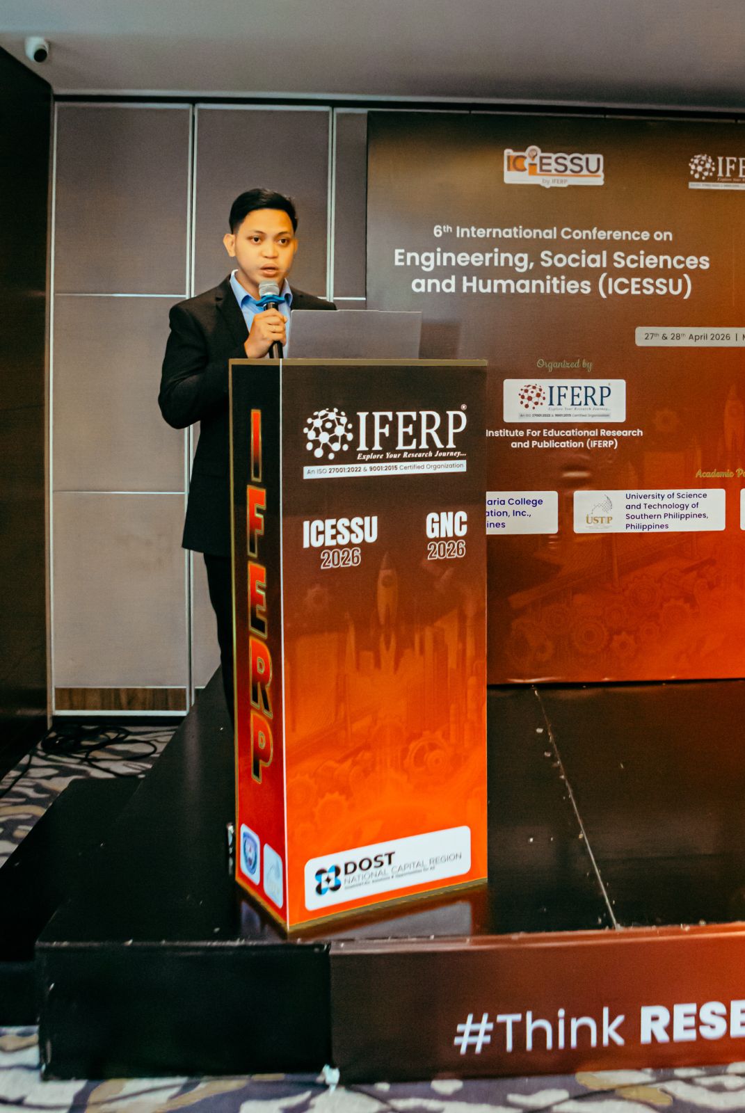 A presenter delivering a talk at the ICESSU podium